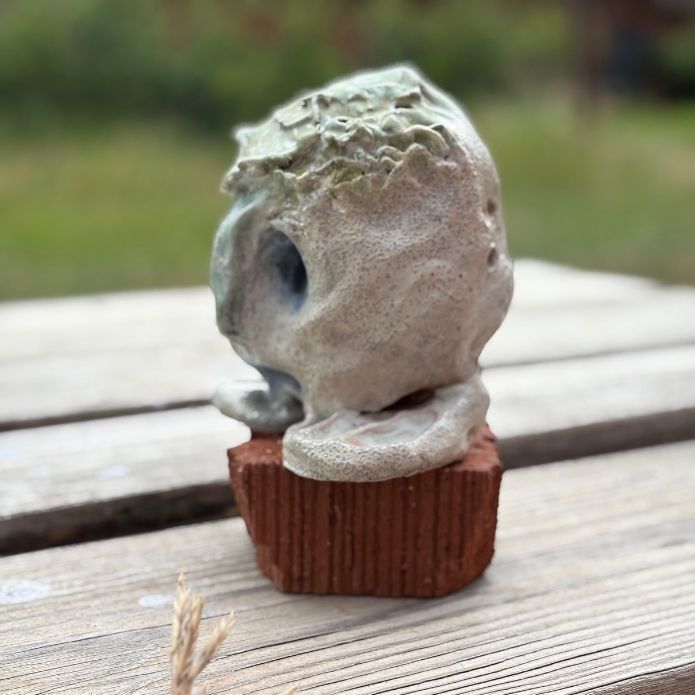 Side angle of “Maybe” ceramic piece with Braille inscription, created by blind artist Cheri Owen as part of her Dream Protector series