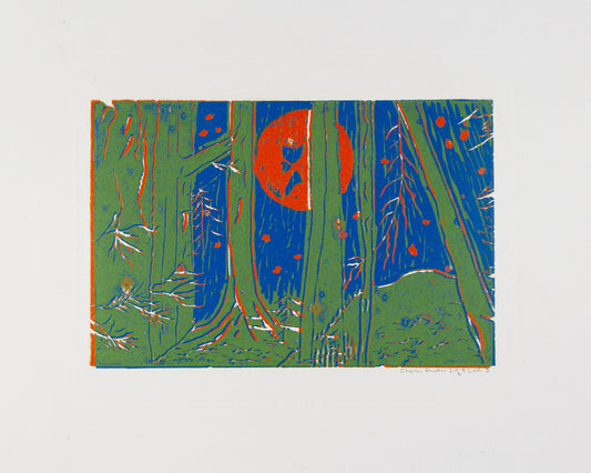Orange Moon behind trees and blue sky 