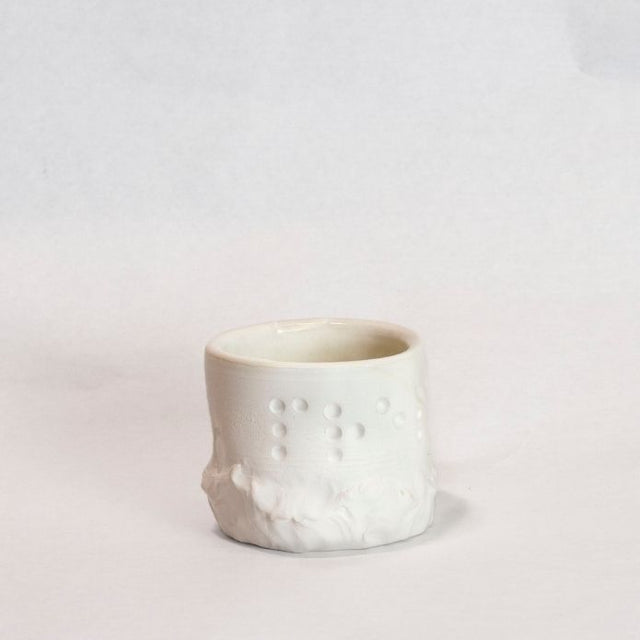 White cup with Braille