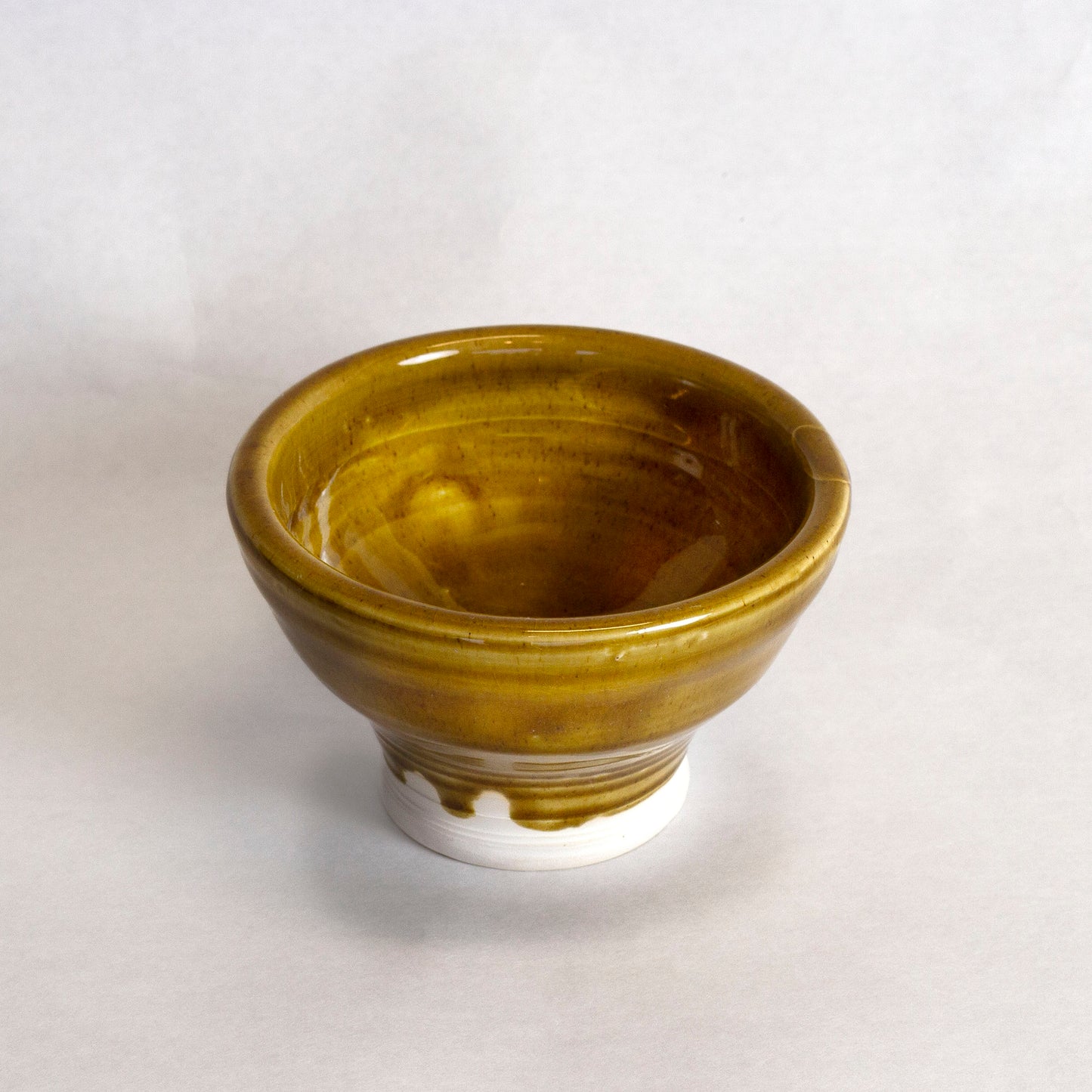 Glazed ceramic bowl with a golden-brown finish. 