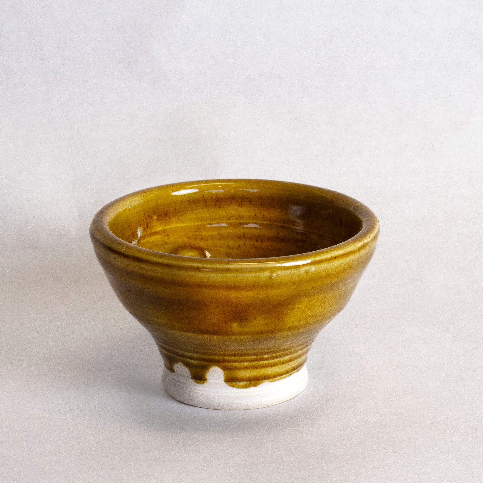 Glazed ceramic bowl with a golden-brown finish. 