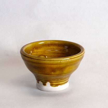 Glazed ceramic bowl with a golden-brown finish. 