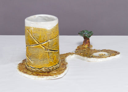 Saucer and Mug textured yellow ceramic set with abstract shapes with a small green tree.