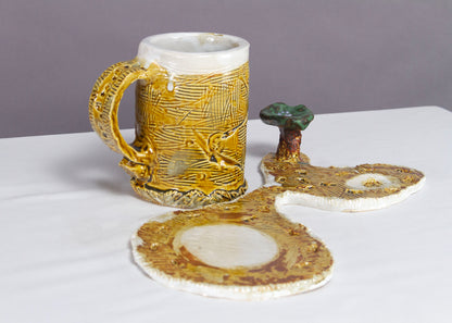 Saucer and Mug textured yellow ceramic set with abstract shapes with a small green tree.