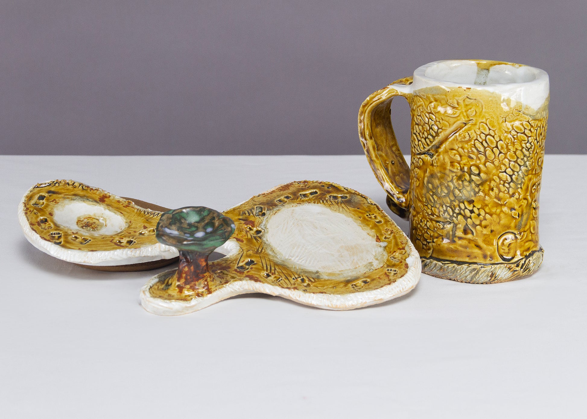 Saucer and Mug textured yellow ceramic set with abstract shapes with a small green tree.