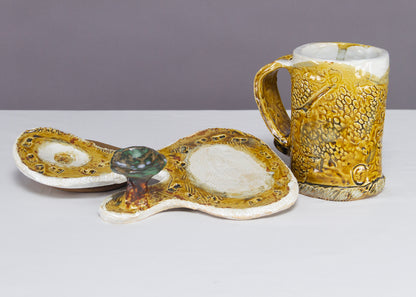 Saucer and Mug textured yellow ceramic set with abstract shapes with a small green tree.