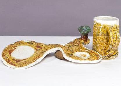 Saucer and Mug textured yellow ceramic set with abstract shapes with a small green tree.