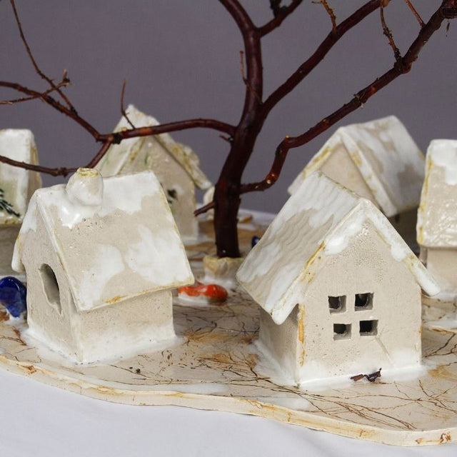 Small white houses under a bare tree branch