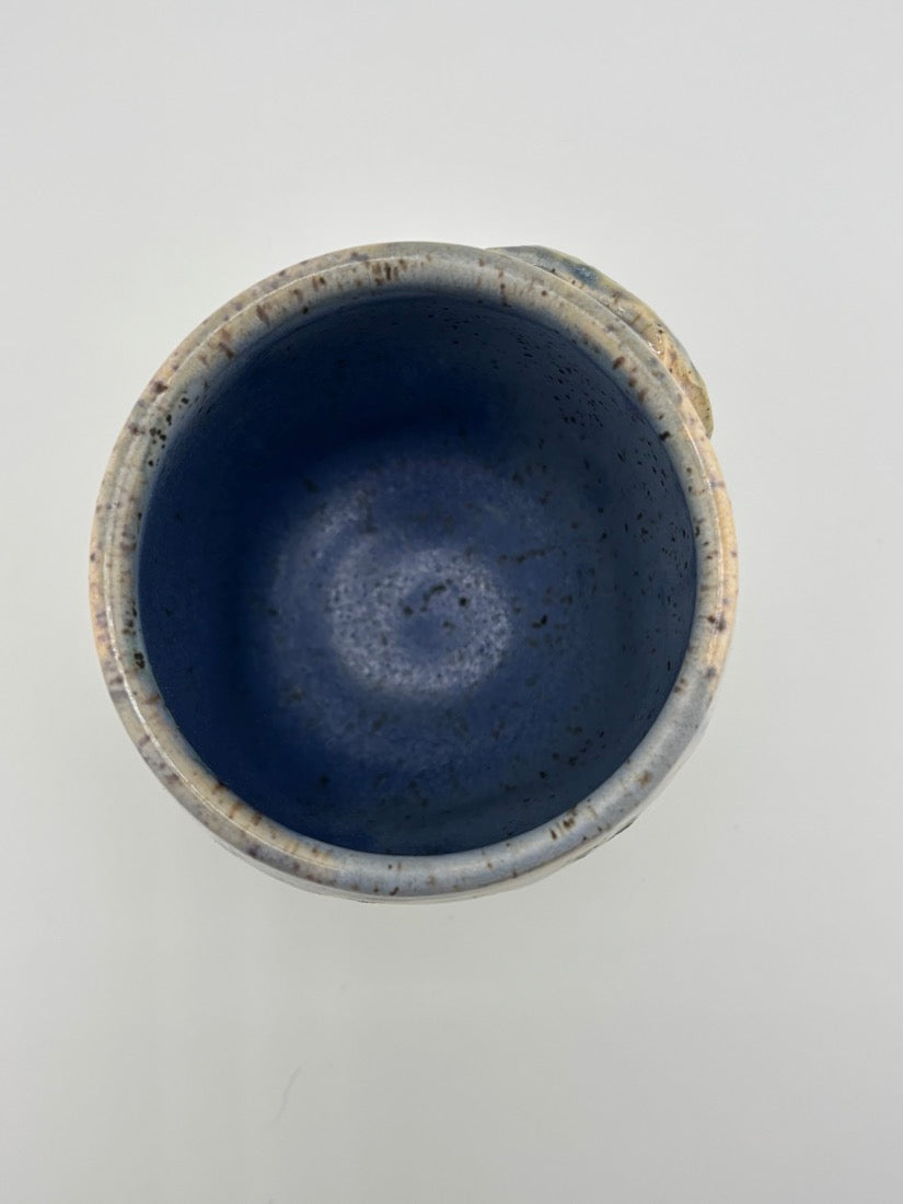 Top-down view of a ceramic cup showing smooth, speckled blue interior glaze.