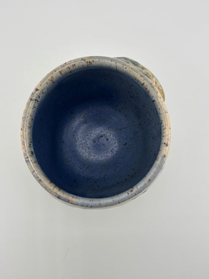 Top-down view of a ceramic cup showing smooth, speckled blue interior glaze.