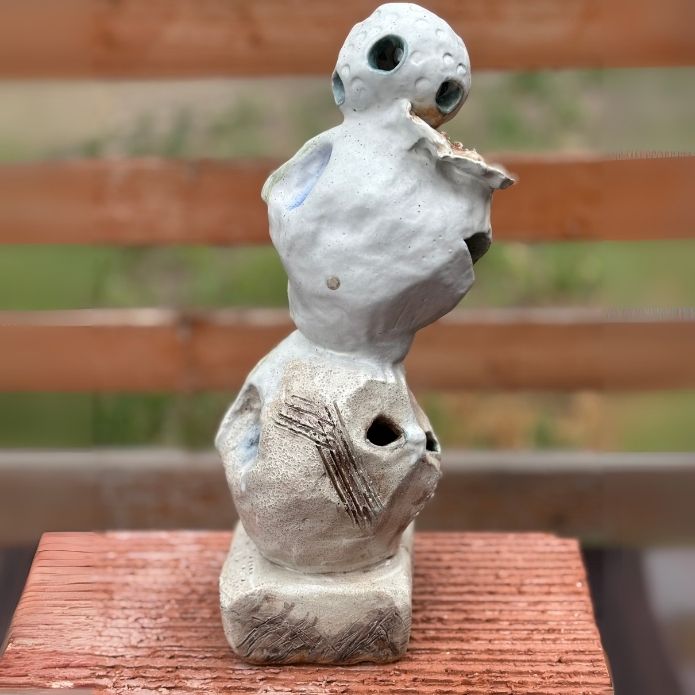 Side view of Cheri Owen’s ceramic sculpture titled “You Are Safe Totem,” featuring textured glaze and Braille message “You Are Safe”