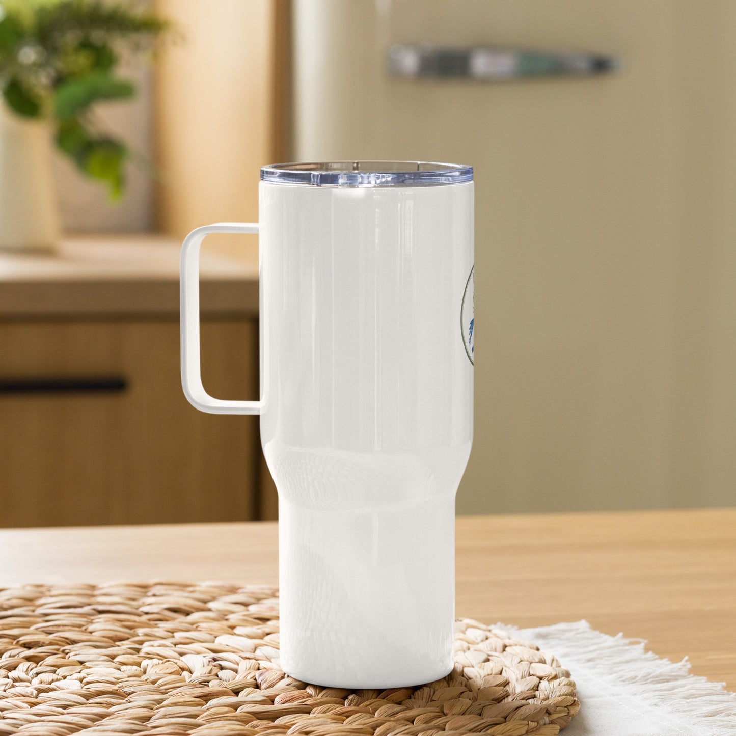 White travel mug with handle on a woven mat in a kitchen setting